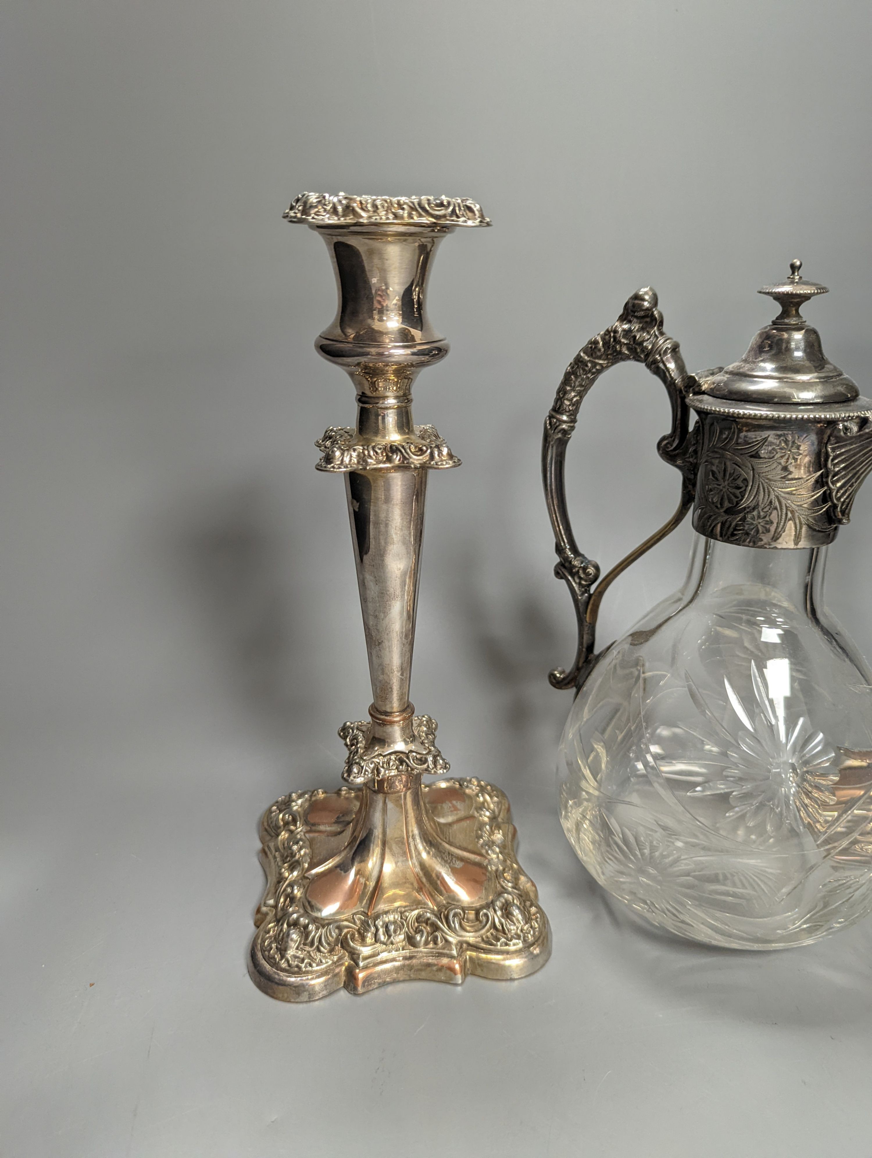 A Victorian electroplate mounted glass Claret jug, 23.5cm high and a pair of candlesticks